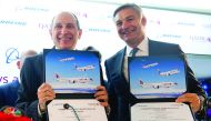 Akbar Al Baker, CEO of Qatar Airways, and Ray Conner, President and CEO of Boeing Commercial Airplanes, hold up commemorative certificates of purchase after announcing a deal for 100 Boeing airplanes, in an order worth $18.6bn, in Washington, yesterday.