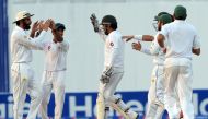 Pakistani cricket captain Misbah-ul-Haq (L) celebrates with teammates after the dismissal of the West Indies' batsman Kraigg Brathwaite on the second day of the second test between Pakistan and West Indies at the Sheikh Zayed Cricket Stadium in Abu Dhabi 