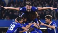 Chelsea's English defender Gary Cahill (top) jumps onto the huddle to join the celebrates after Chelsea's French midfielder N'Golo Kante scored their fourth goal during the English Premier League football match between Chelsea and Manchester United at Sta