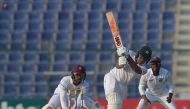 Pakistani batsman Sami Aslam (C) plays a shot as West Indies' wicketkeeper Shai Hope (L) looks on during the third day of the second Test between Pakistan and the West Indies at the Sheikh Zayed Cricket Stadium in Abu Dhabi on October 23, 2016. (AFP / AAM