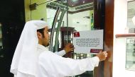 A Ministry official putting up a notice announcing the cancellation of the licence for promotion at a jewellery shop.