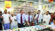 A cake being cut to celebrate Carrefour Qatar's 16th anniversary.