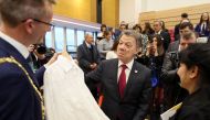 Colombian President Juan Manuel Santos (C) is presented with an Irish Linen shirt by Belfast Lord Mayor Alderman Brian Kingston (L) and made by Maria Cardens (R) during a visit to the Girwood community Hub in north Belfast on November 3, 2016. Santos is t