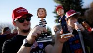 A man holds bobble-head dolls of Clinton and Trump as supporters stand in line to attend a rally with Republican presidential nominee Donald Trump in a cargo hangar at Minneapolis Saint Paul International Airport in Minneapolis, Minnesota, U.S. November 6