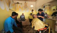 Iraqi men are seen at a barber shop in Intisar district of Mosul, Iraq, November 14, 2016. REUTERS/Ari Jalal