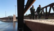  U.S. Border Patrol agents walk over a canal of water flowing into Mexico at the U.S.-Mexico border fence on November 17, 2016 in San Luis, Arizona. The U.S. government has built triple fencing to deter illegal immigrants and smugglers who previously easi