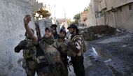  A soldier from the Iraqi Special Forces takes a selfie on a street in the Aden district of Mosul after troops almost entirely retook the area from Islamic State (IS) group jihadists on November 22, 2016.  AFP / THOMAS COEX
