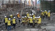 Rescue workers search at the site where a power plant`s cooling tower under construction collapsed in Fengcheng. Photo: Reuters.