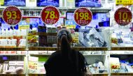 A woman looks at items outside an outlet store at a shopping district in Tokyo.