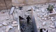 A member of Syrian pro-government forces inspects an area on November 27, 2016 in the Masaken Hanano district in eastern Aleppo, a day after they resized it from rebel fighters.  AFP / GEORGE OURFALIAN
