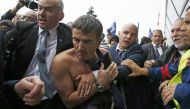 File photo of a shirtless Xavier Broseta (2ndL), Executive Vice President for Human Resources and Labour Relations at Air France, who was evacuated by security after employees interrupted a meeting with representatives staff at the Air France headquarters
