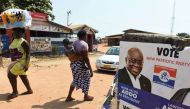 People walk past a campaign poster of Presidential candidate of the opposition New Patriotic Party (NPP) Nana Akufo-Addo in Accra, on December 3, 2016 ahead of the December 7 election. PHOTO | PIUS UTOMI EKPEI | AFP.