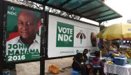Street vendors sell wares in Accra, on December 2, 2016, next to an electoral poster of President John Mahama, who is the candidate of the ruling Democratic Congress (NDC) ahead of the December 7 presidential elections. AFP / Pius Utomi EKPEI