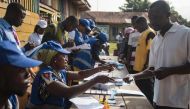 Electoral officers explain how to vote for the presidential election at a polling station in Kibi, southern Ghana, on December 7, 2016. Ghanaians cast their ballots in neck and neck presidential and parliamentary polls held at a time of economic woes and