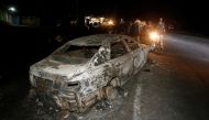 People look at the wreckage of a car burnt after a fireball from an tanker engulfed several vehicles and killed several people, near the Rift Valley town of Naivasha, west of Kenya's capital Nairobi, December 11, 2016. REUTERS/Thomas Mukoya