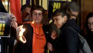 City councillor of Barcelona's city hall and member of radical left-wing Catalan independentist political party CUP (Popular Unity Candidates) Maria Robira (R) and CUP's deputy Mireia Vehi burn a picture of Spain's King during an anti-monarchy demonstrati