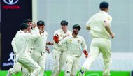 Australia's team players celebrate the dismissal of Pakistan's batsman Azhar Ali during the second day of the day-night Test match at the Gabba in Brisbane, yesterday.