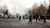This picture obtained from the Ihlas News Agency shows a police officer and people walking next to the wreck of public bus following an explosion on December 17, 2016 in Kayseri, central Turkey. Turkey OUT / AFP / IHLAS NEWS AGENCY / IHLAS NEWS AGENCY