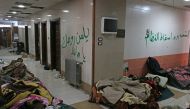 Injured and sick people wait inside a hospital to be evacuated from a rebel-held sector of eastern Aleppo, Syria December 17, 2016. The arabic on the wall reads: 'The people want to bring down the regime' (R) and 'Curse your soul, oh Hafez' (L). REUTERS/A