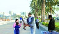 Children looking at a bird-shaped kite on the Corniche yesterday bought from a vendor. Pic: Salim Matramkot / The Peninsula