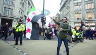 People gather to demonstrate condemning massacres and attacks in Syria's Aleppo over civilians in a march from Marble Arch to Downing Street in London, yesterday.
