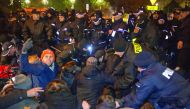 People scuffle with police as they try to block the road to the Polish Parliament in Warsaw.