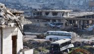 A bus drives through the government-controlled crossing of Ramoussa, on the southern outskirts of Aleppo, on December 18, 2016, during an evacuation operation of rebel fighters and civilians from rebel-held areas. George Ourfalian/AFP.