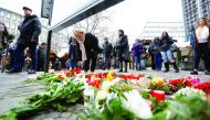 People gather to lay down flowers for the deceased outside the Gedaechniskirche.