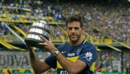 Argentinian tennis player Juan Martin del Potro holds a Davis Cup 2016 trophy replica while poseing for the photographer before the Argentina's First Division football match between Boca Juniors and Colon at La Bombonera stadium, in Buenos Aires, on Decem