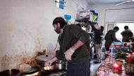 Chef Talal Rankoussi and other Syrian volunteers prepare a meal in 
