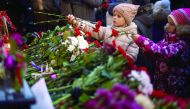 Two girls lay flowers at the home stage building of the Alexandrov Ensemble (The Red Army Choir), in Moscow.
