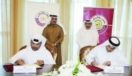Minister of Transport and Communications H E Jassim bin Saif Al Sulaiti (standing right) and Head of the Court of Cassation and President of the Supreme Judiciary Council, Masoud Mohamed Al Amirthe, witnessing the signing of a Memorandum of Understanding 