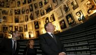 FILE PHOTO: Romanian President Klaus Iohannis looks at pictures of Jews killed in the Holocaust during a visit to the Hall of Names at Yad Vashems Holocaust History Museum in Jerusalem, March 8, 2016 (REUTERS / Ammar Awad) 