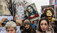 Women hold posters as they take part in a march for women's rights and freedom in solidarity with the march organised in Washington, on January 21, 2017 in Pristina. Hundreds of thousands of protesters spearheaded by women's rights groups are set to conve