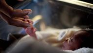 A man touches his newborn baby at the Israeli hospital in Port-au-Prince, January 20, 2010 (REUTERS / Carlos Garcia Rawlins) 