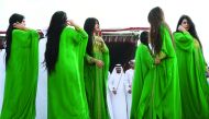 Emiratis perform a traditional dance during the camel festival at the Sweihan racecourse, in Al-Ain on the outskirts of Abu Dhabi yesterday. The festival includes a camel beauty contest, a traditional souq, a camel auction, and competitions for traditiona
