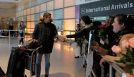 Laura Atlas Kravitz, an opponent of US President Donald Trump's executive order travel ban, hands a flower to an arriving international traveler at Logan Airport in Boston, Massachusetts, US February 3, 2017. Reuters/Brian Snyder