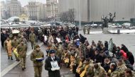 People kneel as servicemen carry a coffin with the body of an Ukrainian serviceman who died during fighting in the eastern Ukrainian town of Avdiivka, in Donetsk region, during obsequies on Independence Square in Kiev on February 3, 2017. (AFP / Sergei SU