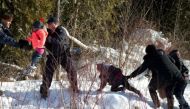 Royal Canadian Mounted Police (RCMP) officers assist a child from a family that claimed to be from Sudan as they walk across the U.S.-Canada border into Hemmingford, Canada, from Champlain in New York. REUTERS/Christinne Muschi