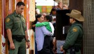 FILE PHOTO - U.S. Border patrol agents stand at an open gate on the fence along the Mexico border to allow Luis Eduardo Hernandez-Bautista hug Ty'Jahnae Williams and his father Eduardo Hernandez (not in view), as part of Universal Children's Day at the Bo