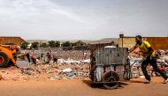 (FILES) This file photo taken on March 08, 2017 shows a garbage scavenger pushing a cart through a dump in Bamako. AFP / SEBASTIEN RIEUSSEC
