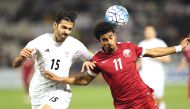 Qatar's Akram Hassan Afif (right) in action with Iran's Pejman Montazeri during the World Cup 2018 Asia qualifying football match at the Jassim Bin Hamad stadium in Doha on Thursday.