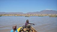 Armed fishermen from Kenya's Turkana county return from a fishing expedition aboard a boat on March 24, 2017 near Lowarengak, on the western shores of Lake Turkana, northern Kenya. Lake Turkana has gradually receded in recent years leading to diminished f