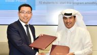 Dr Khalifa Al-Khalifa and Zong Yan exchanging documents.