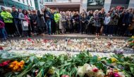People react during a minute of silence to commemorate the victims of Friday's terror attack at a makeshift memorial near the site where a truck drove into Ahlens department store in Stockholm, Sweden, on April 10, 2017. / AFP / Jonathan NACKSTRAND