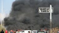 A picture taken on April 15, 2017, shows smoke billowing following a suicide car bombing in Rashidin, west of Aleppo, that targeted buses carrying Syrians evacuated from two besieged government-held towns of Fuaa and Kafraya.  AFP / Ibrahim YASOUF
