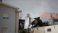 Smoke is seen where a small airplane crashed near a supermarket in a residential area outside Lisbon, Portugal April 17, 2017. REUTERS/Rafael Marchante
