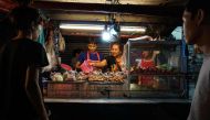 This photo taken on April 17, 2017 shows a family preparing food for customers at a street food stall in the Phrakanong district of Bangkok. AFP / LILLIAN SUWANRUMPHA
