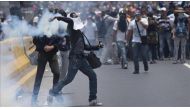 Venezuelan opposition activists throwing back a tear gas canister during clashes with the police in Caracas, Venezuela on April 10, 2017. The center-right opposition vowed fresh street protests -after earlier unrest left dozens of people injured - to incr