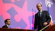 (FILES) This file photo taken on June 20, 2013 shows French President's deputy General Secretary Emmanuel Macron (L) looking on as President Francois Hollande leaves the stage after delivering his speech at the Social Conference, a 2-day conference to dis